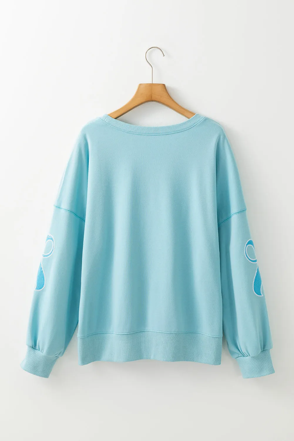 Beau Blue - Sweat-shirt surdimensionné à paillettes et nud papillon à épaules tombantes