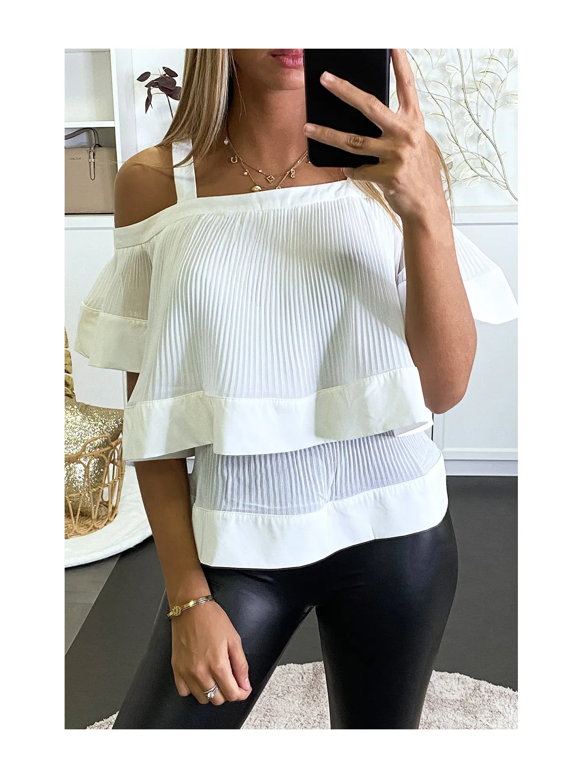 Blouse blanche plissée à col bardot et à volants.