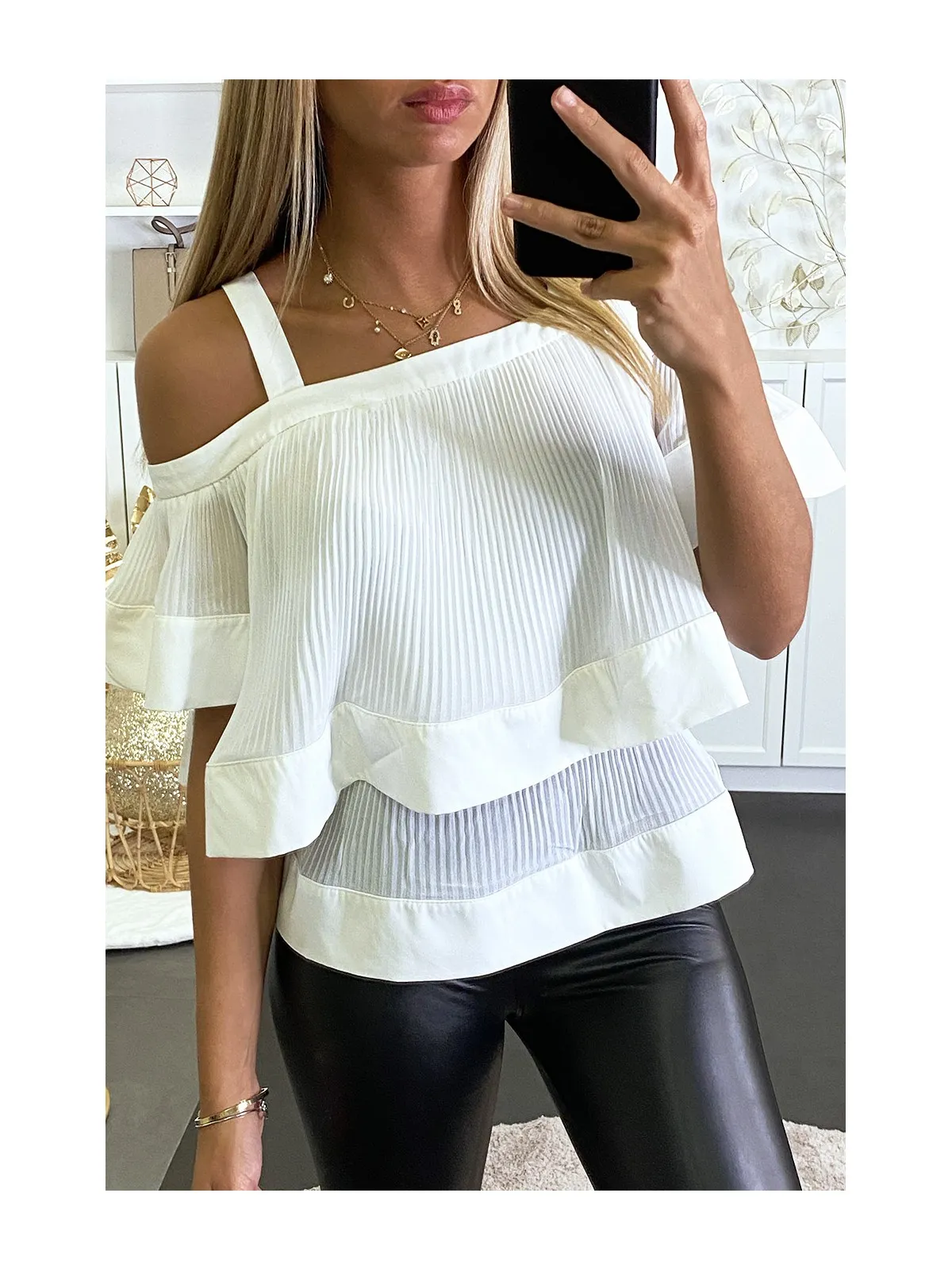 Blouse blanche plissée à col bardot et à volants.